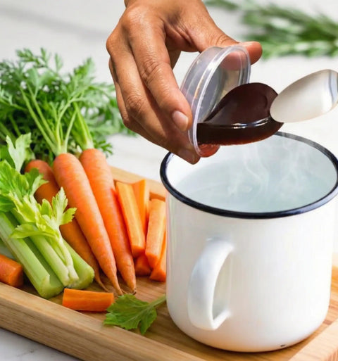 White enamel mug with black rim and handle, filled with steaming water